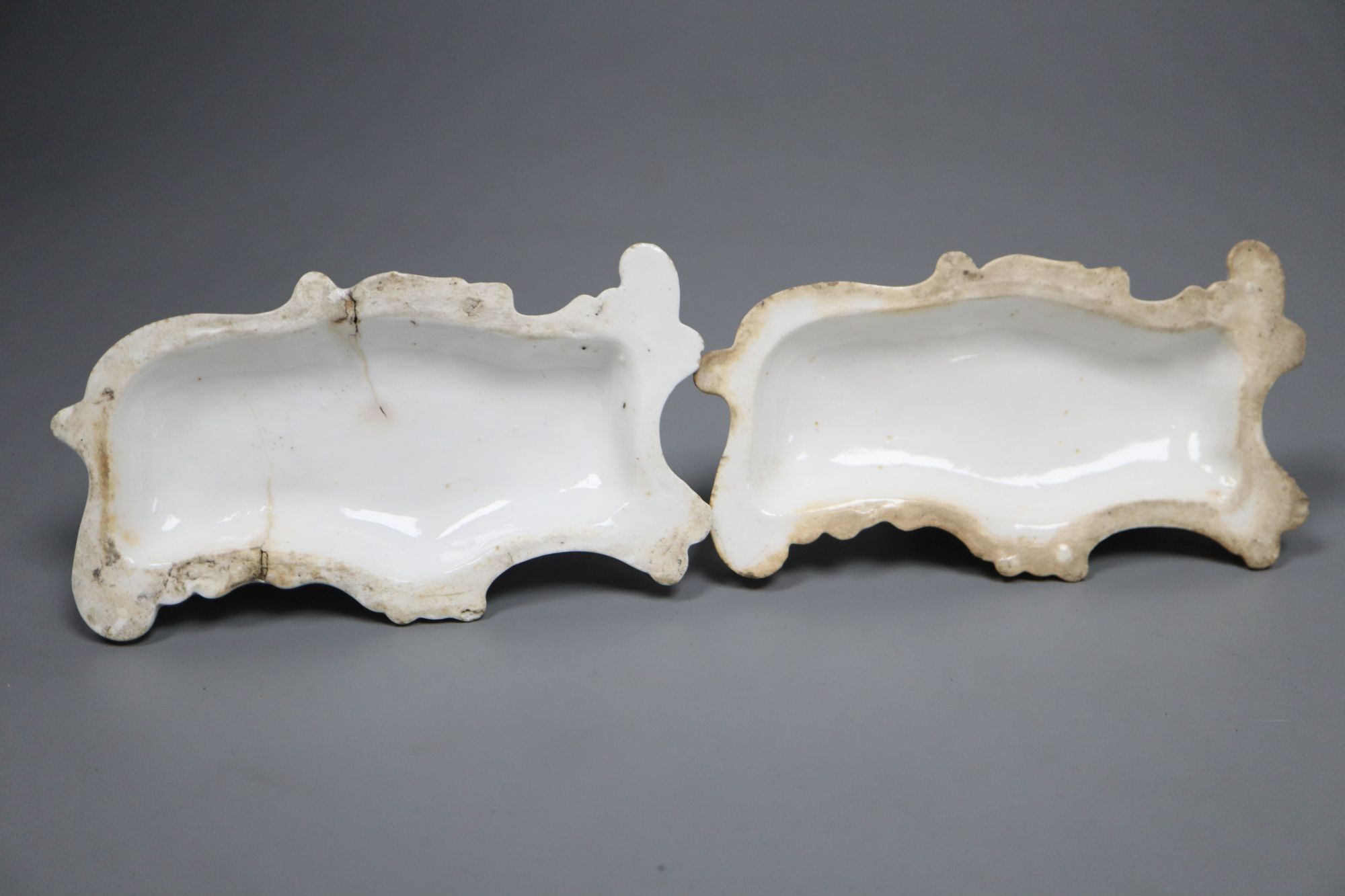 A pair of Staffordshire porcelain figures of recumbent pointers or setters, c.1835-50, 12cm long